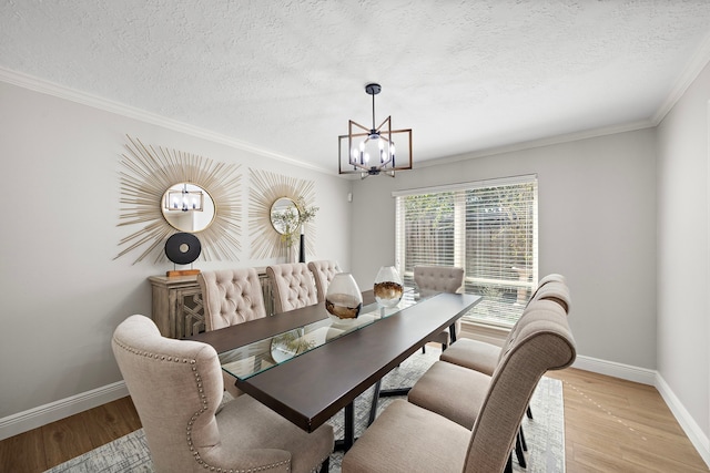 dining area with a notable chandelier, crown molding, light hardwood / wood-style flooring, and a textured ceiling