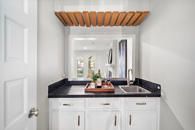 bar with white cabinets and sink