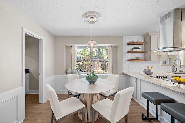 dining room featuring dark wood-type flooring, sink, and a textured ceiling