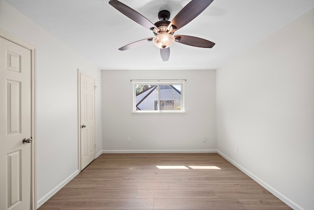 empty room with ceiling fan and light hardwood / wood-style floors