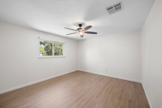 unfurnished room featuring ceiling fan, light wood-type flooring, and a textured ceiling