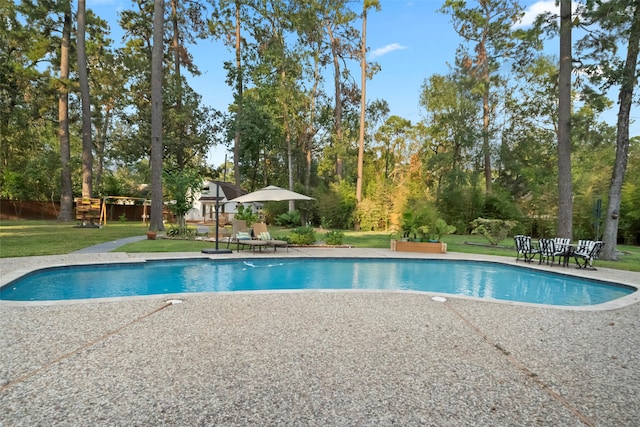 view of swimming pool featuring a yard and a patio area