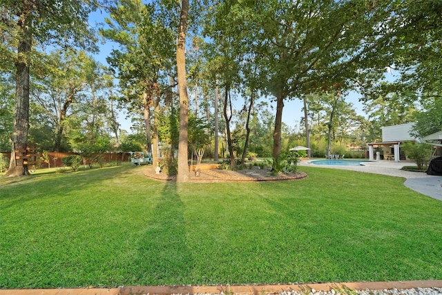 view of yard with a fenced in pool and a patio