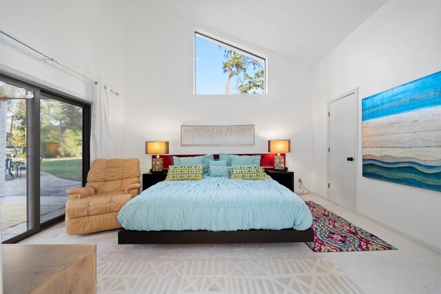 carpeted bedroom with access to exterior, multiple windows, and high vaulted ceiling