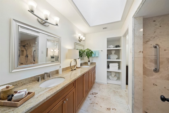 bathroom with a skylight, vanity, and a shower with shower door