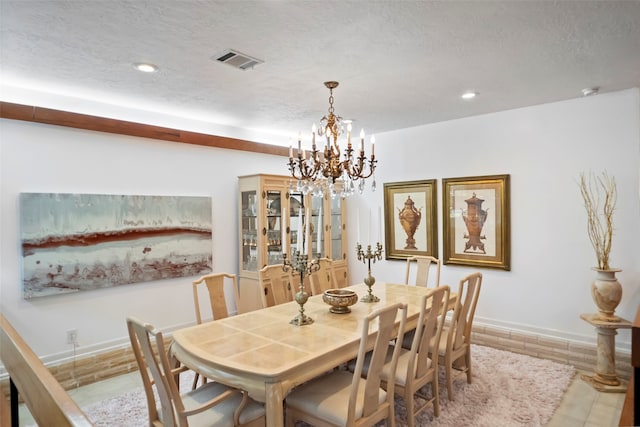 dining area featuring a textured ceiling, a chandelier, and hardwood / wood-style floors