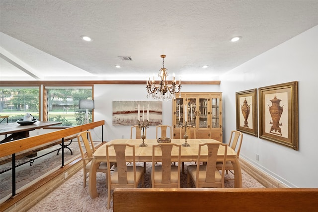 dining room with hardwood / wood-style flooring, an inviting chandelier, and a textured ceiling