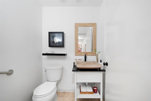 bathroom featuring vanity, tile patterned flooring, and toilet