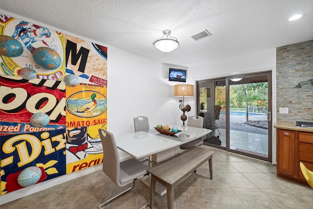 tiled dining room featuring a textured ceiling