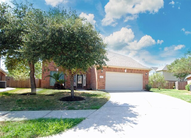 view of front facade with central air condition unit, a garage, and a front yard