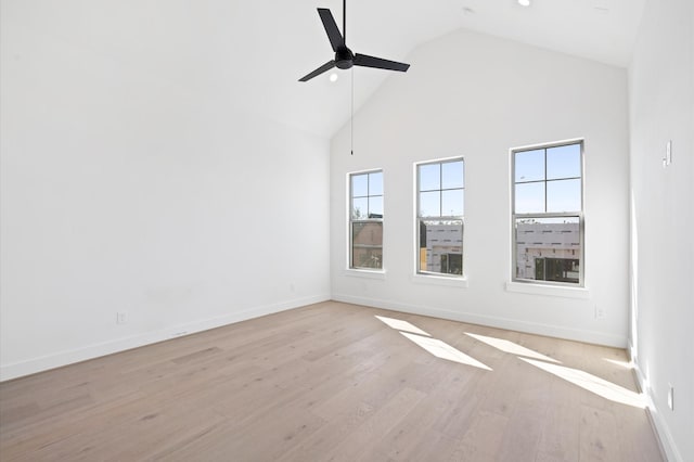 empty room with ceiling fan, light hardwood / wood-style flooring, and high vaulted ceiling