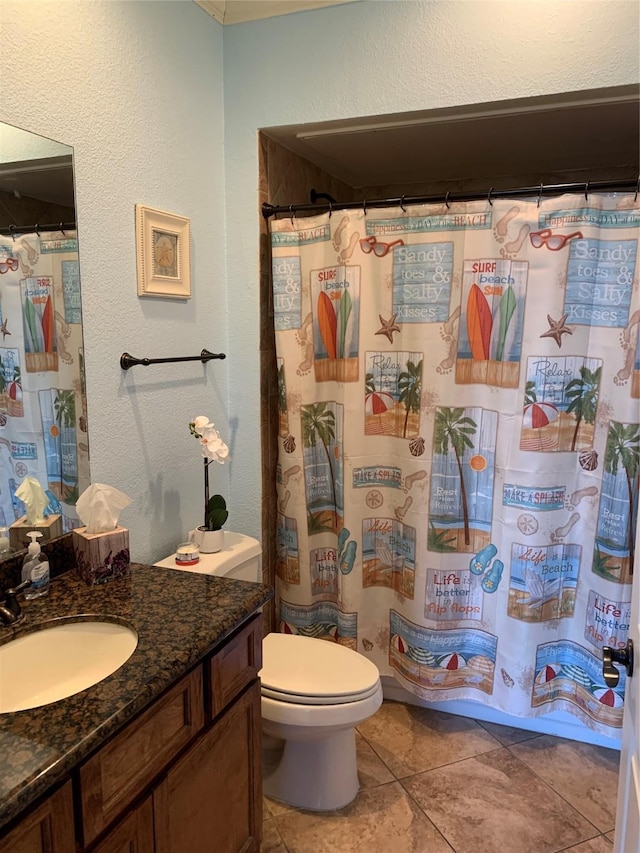 bathroom featuring a shower with shower curtain, tile patterned floors, vanity, and toilet