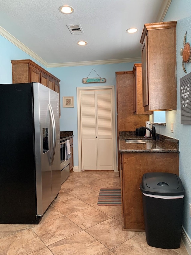 kitchen featuring stainless steel appliances, sink, light tile patterned floors, and crown molding