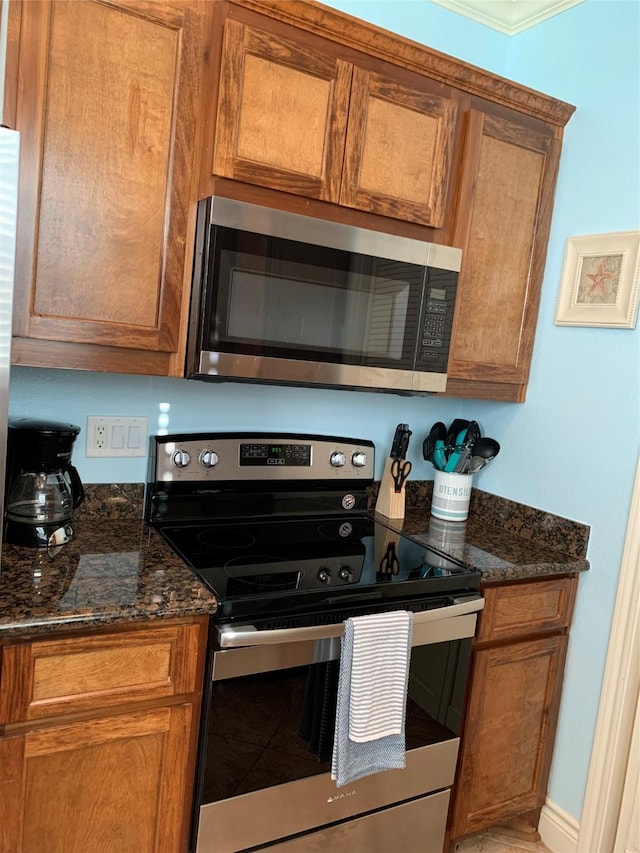 kitchen with stainless steel appliances and dark stone countertops