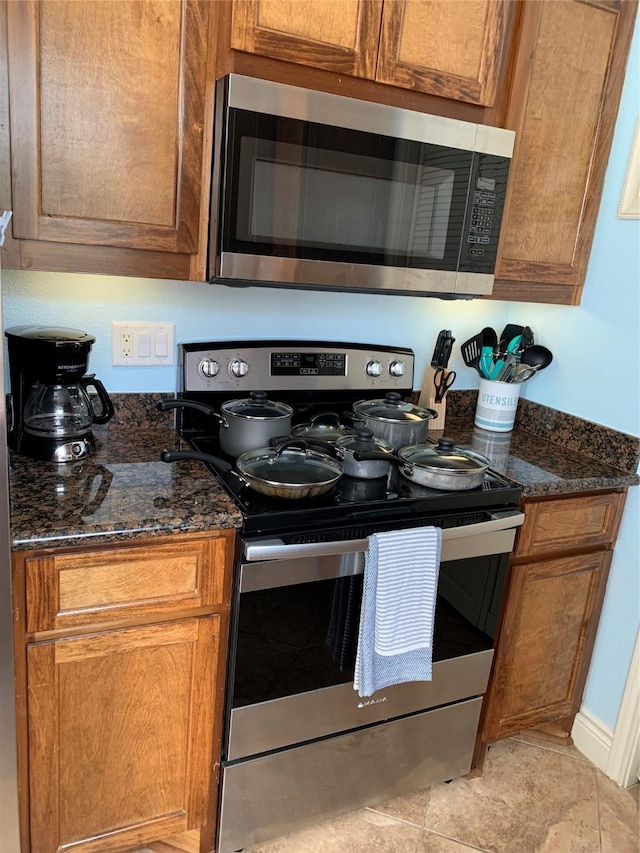 kitchen featuring appliances with stainless steel finishes and dark stone counters