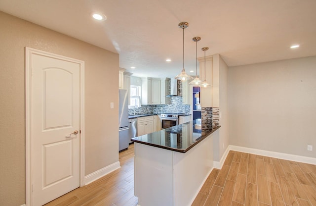 kitchen featuring pendant lighting, kitchen peninsula, decorative backsplash, white cabinetry, and stainless steel appliances