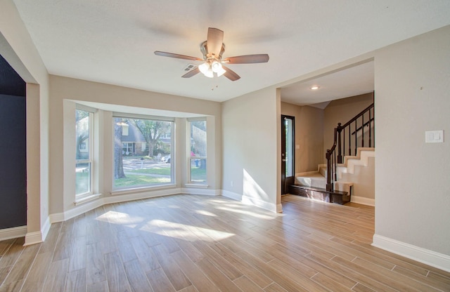 unfurnished living room with light hardwood / wood-style flooring and ceiling fan