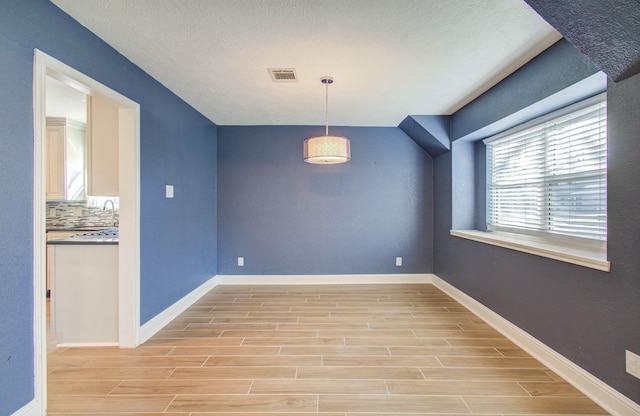 unfurnished dining area featuring light wood-type flooring