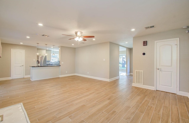 unfurnished living room with ceiling fan and light wood-type flooring