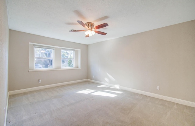 carpeted empty room with ceiling fan and a textured ceiling