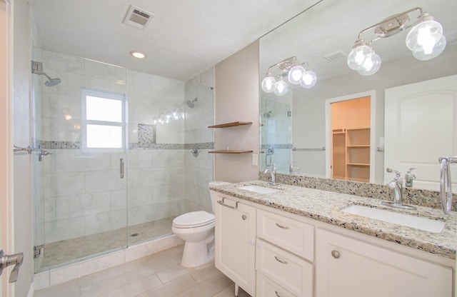 bathroom with tile patterned floors, vanity, an enclosed shower, and toilet