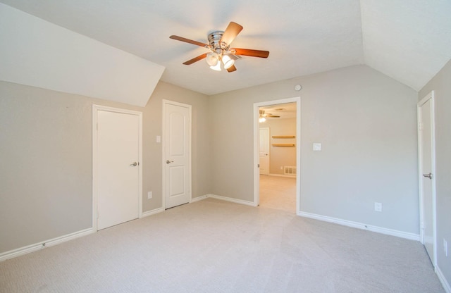 unfurnished bedroom featuring ceiling fan, light carpet, and vaulted ceiling