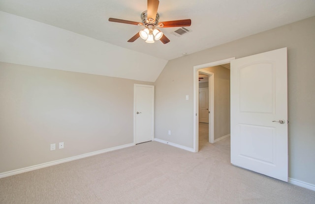 unfurnished bedroom with ceiling fan, lofted ceiling, and light carpet