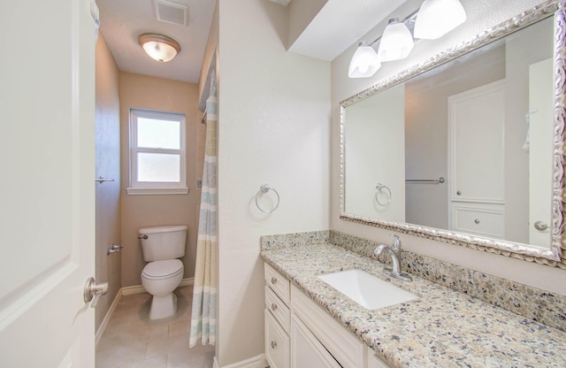 bathroom with tile patterned floors, vanity, toilet, and walk in shower