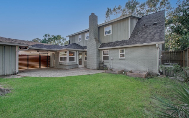 back of house with a lawn, cooling unit, and a patio