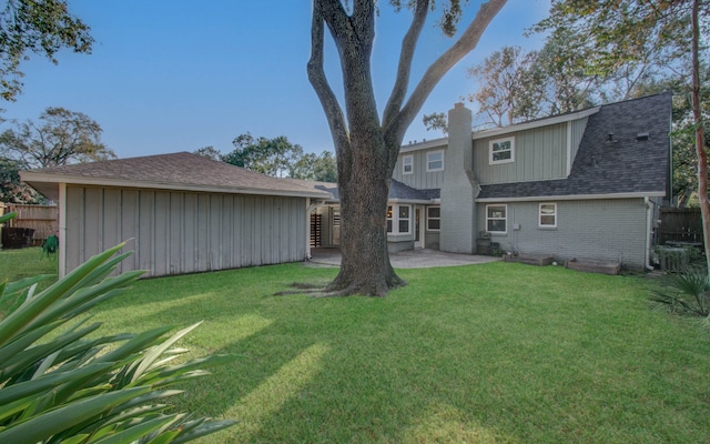 rear view of house featuring a yard and a patio