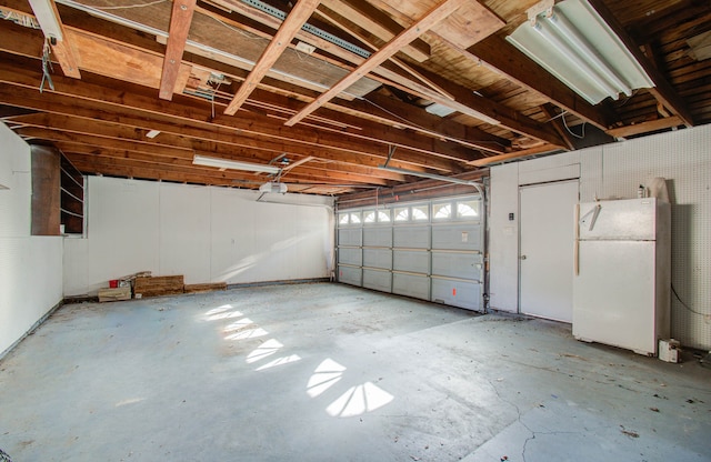 garage with white fridge and a garage door opener