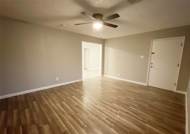 unfurnished room with a textured ceiling, hardwood / wood-style flooring, and ceiling fan