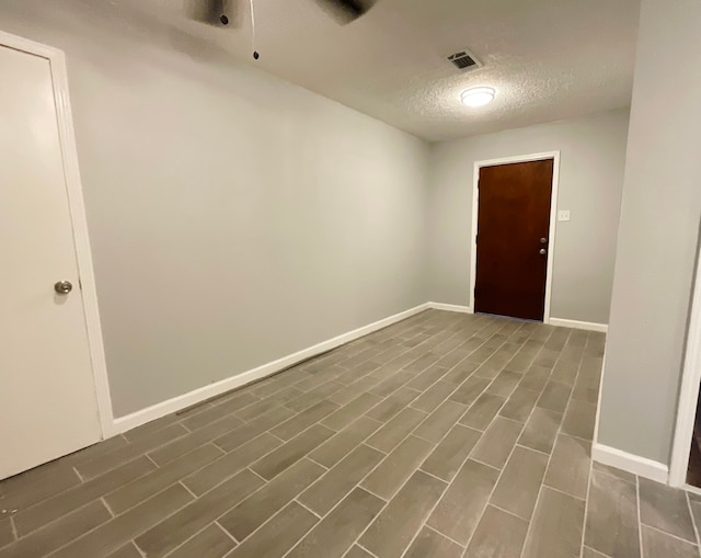 unfurnished room with dark wood-type flooring and a textured ceiling