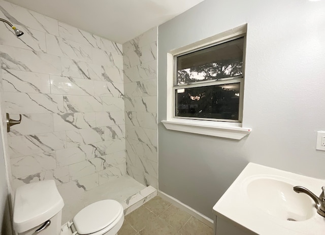 bathroom featuring a tile shower, toilet, tile patterned floors, and vanity