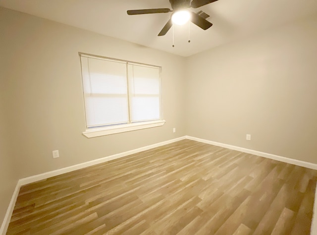 empty room with hardwood / wood-style floors and ceiling fan