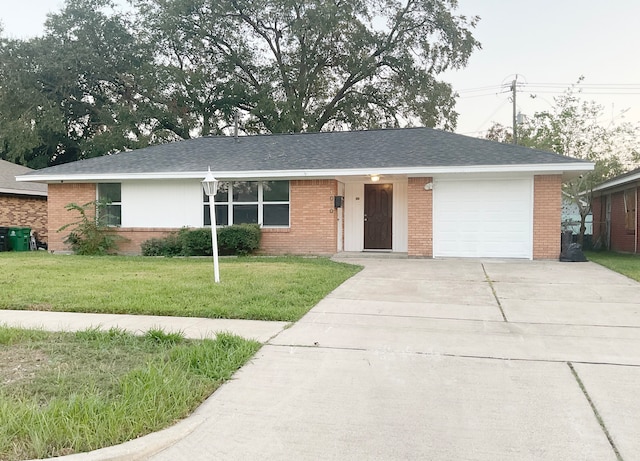 single story home featuring a garage and a front lawn