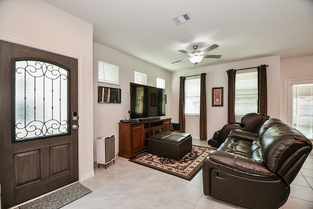 tiled living room with ceiling fan and a wealth of natural light