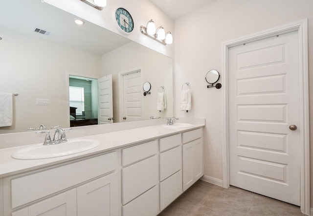 ensuite bathroom featuring tile patterned floors, visible vents, a sink, and ensuite bathroom