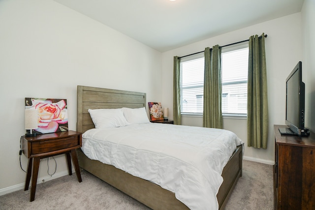 bedroom featuring lofted ceiling and light carpet