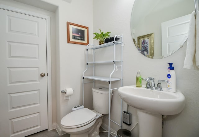 bathroom with baseboards and toilet