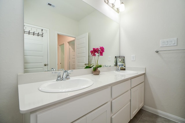 full bathroom with double vanity, visible vents, a sink, and tile patterned floors