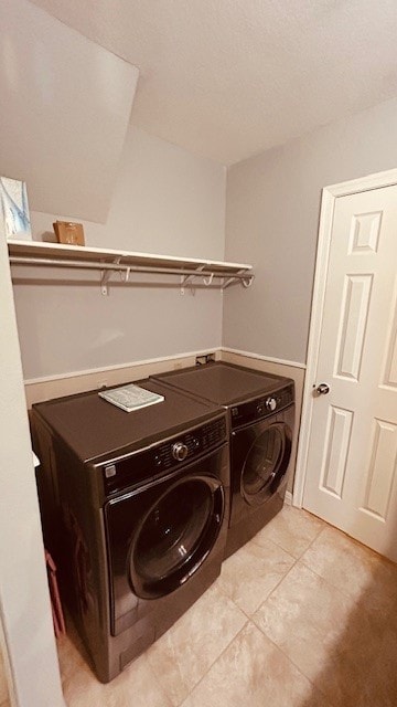 laundry area featuring light tile patterned floors and washer and clothes dryer