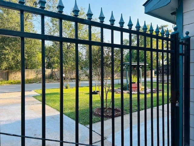 view of gate with a yard