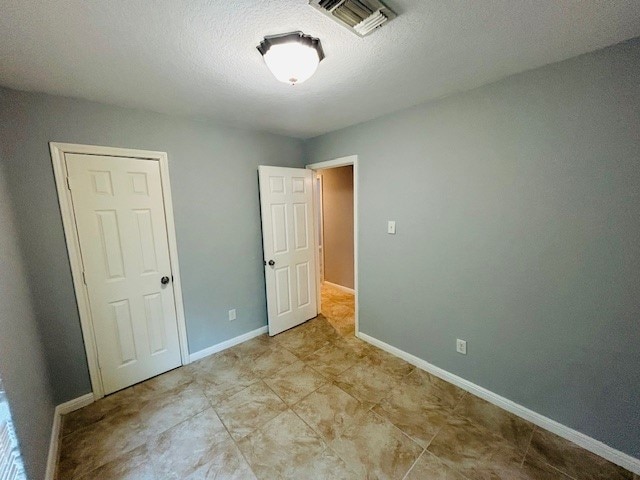 unfurnished bedroom with a textured ceiling