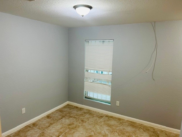 spare room with a textured ceiling