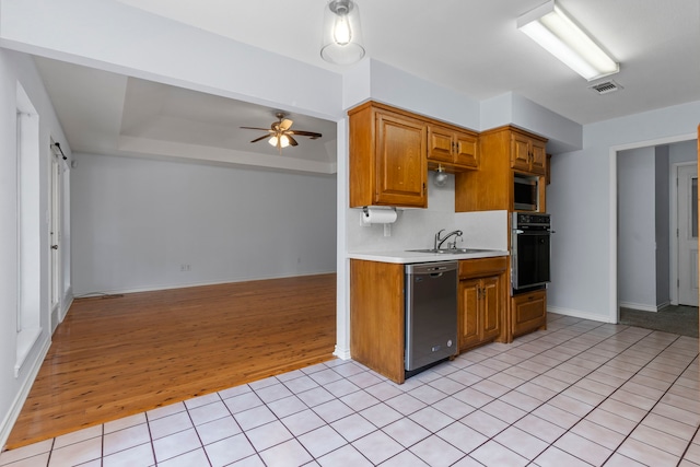 kitchen with light wood-type flooring, ceiling fan, stainless steel appliances, sink, and backsplash