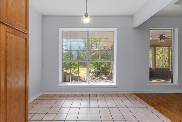 interior space featuring beamed ceiling, light hardwood / wood-style flooring, and ceiling fan