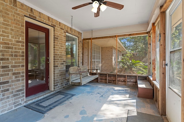 unfurnished sunroom featuring ceiling fan