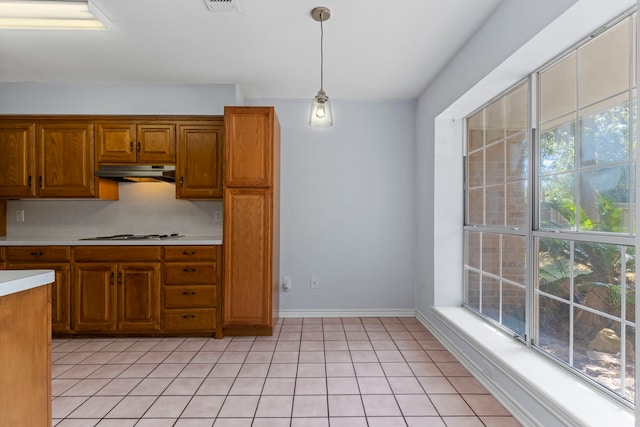 kitchen featuring a healthy amount of sunlight, decorative light fixtures, white gas cooktop, and tasteful backsplash