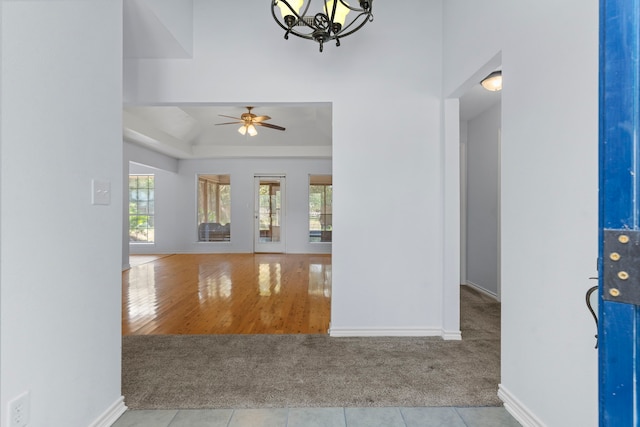 entrance foyer with ceiling fan with notable chandelier and light hardwood / wood-style flooring